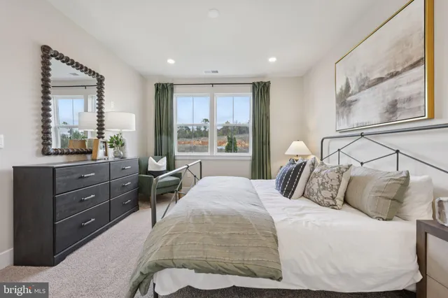 a bedroom with a bed and large windows