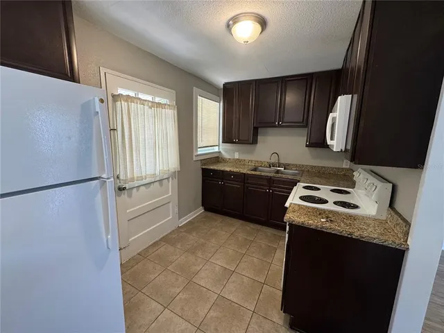 a kitchen with stainless steel appliances granite countertop a stove a refrigerator and a sink