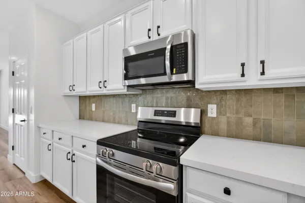 a kitchen with granite countertop white cabinets and a stove