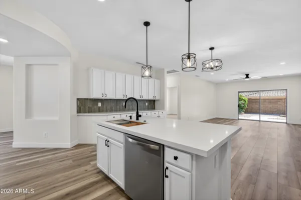a kitchen with kitchen island a counter space a sink appliances and cabinets