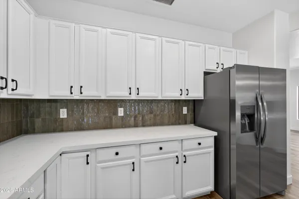 a kitchen with a refrigerator a sink and cabinets
