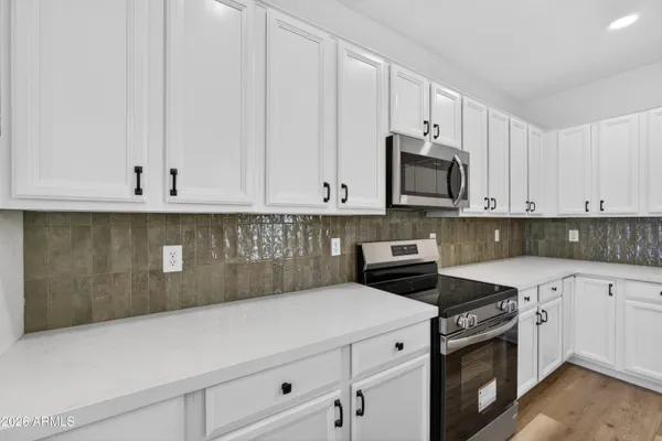 a kitchen with granite countertop white cabinets and sink