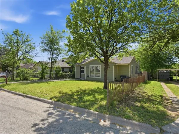 a front view of a house with a yard and trees