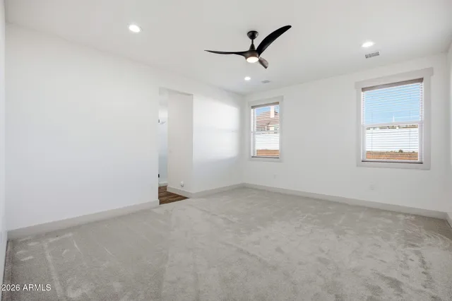 an empty room with a ceiling fan and window