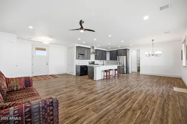 a living room with stainless steel appliances kitchen island furniture and wooden floor