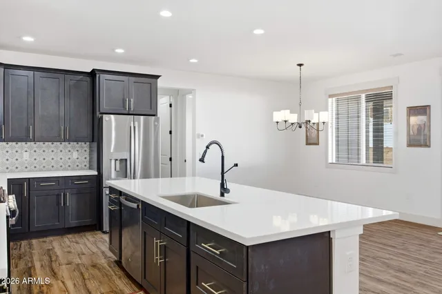 a kitchen with kitchen island a sink appliances and wooden cabinets