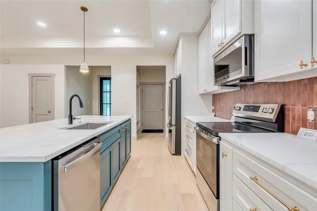a large kitchen with kitchen island a sink stainless steel appliances and cabinets