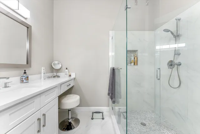 a bathroom with a granite countertop sink a toilet and shower