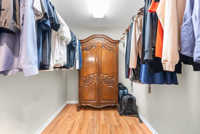 a view of walk in closet with clothes and shoes