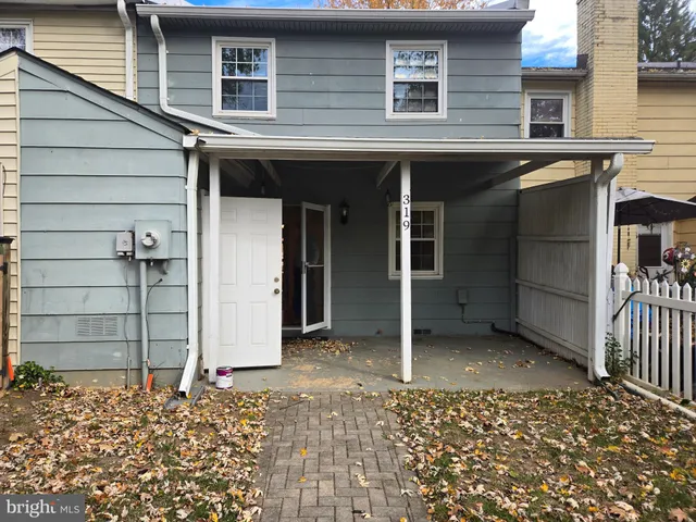 a view of a house with a door and wooden bench