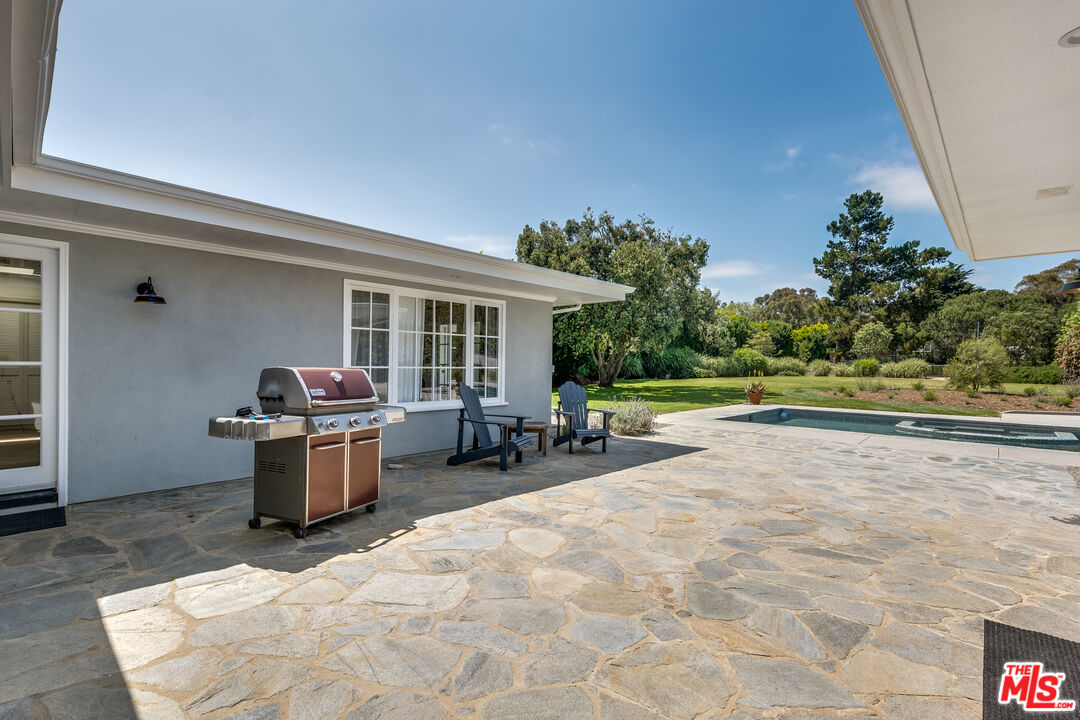 28925 Cliffside Drive Malibu, CA 90265 - Photo 50 of 62 a view of a patio with dining table and chairs under an umbrella