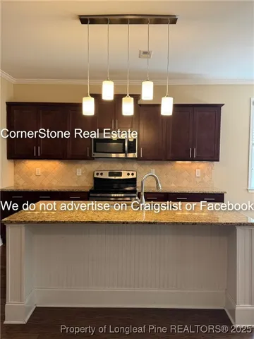 a kitchen with kitchen island granite countertop a refrigerator and a stove