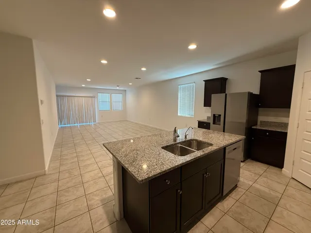 a large kitchen with stainless steel appliances a sink and a microwave
