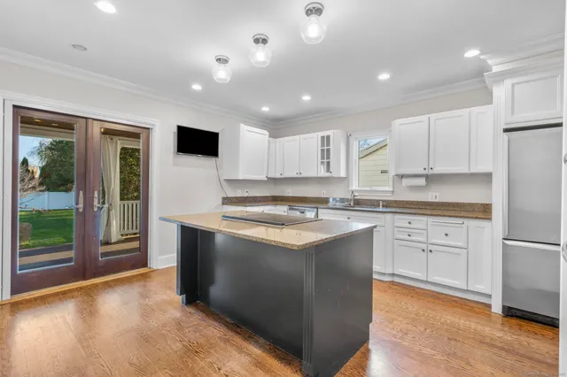 a kitchen with stainless steel appliances granite countertop a stove a sink and a refrigerator