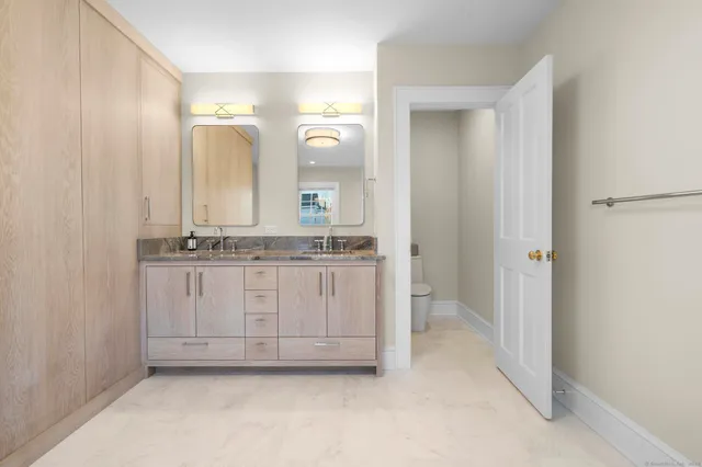 a view of a double vanity sink mirror and cabinets
