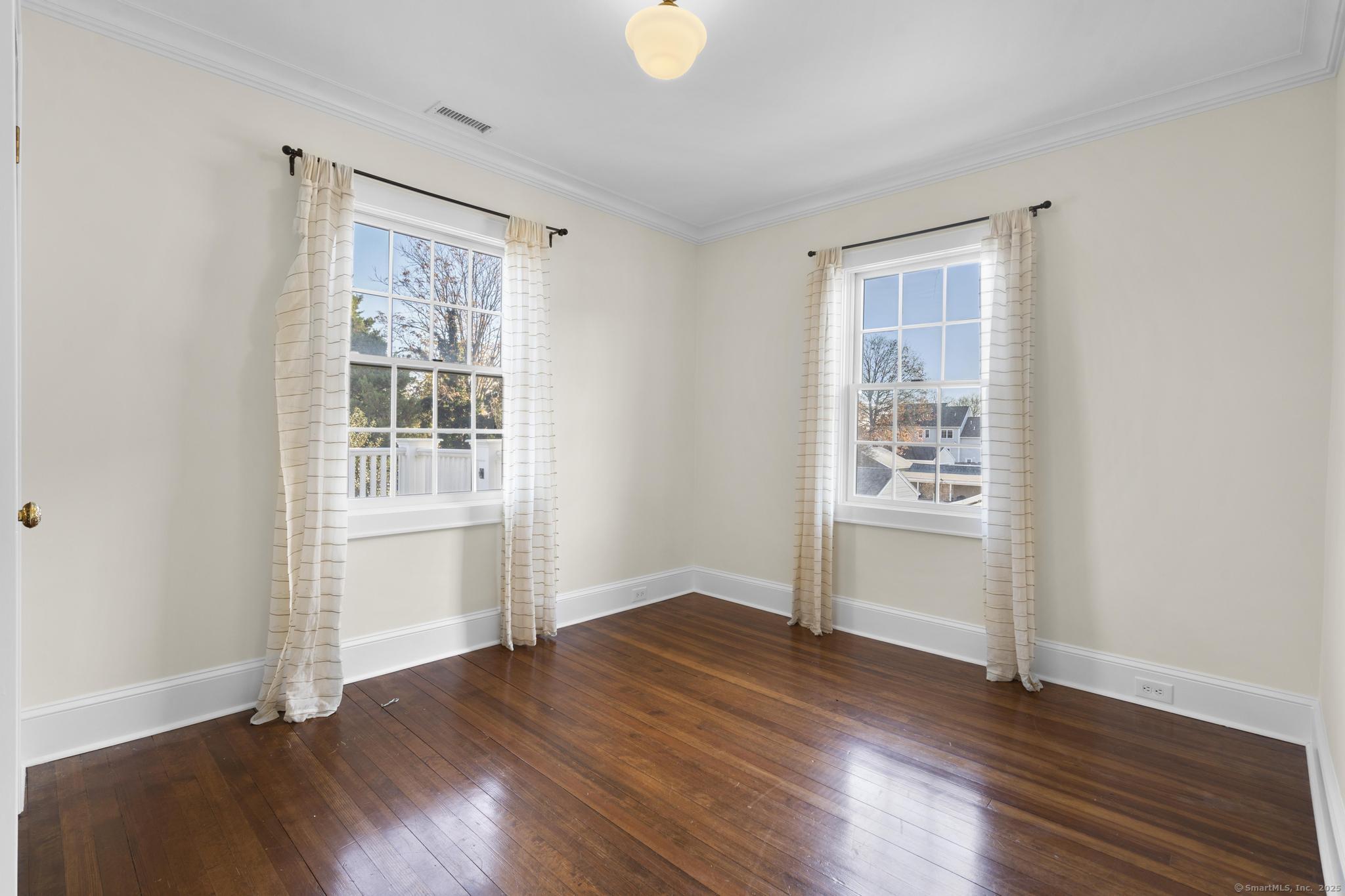 447 Reef Road Fairfield, CT 06824 - Photo 18 of 27 an empty room with wooden floor and windows