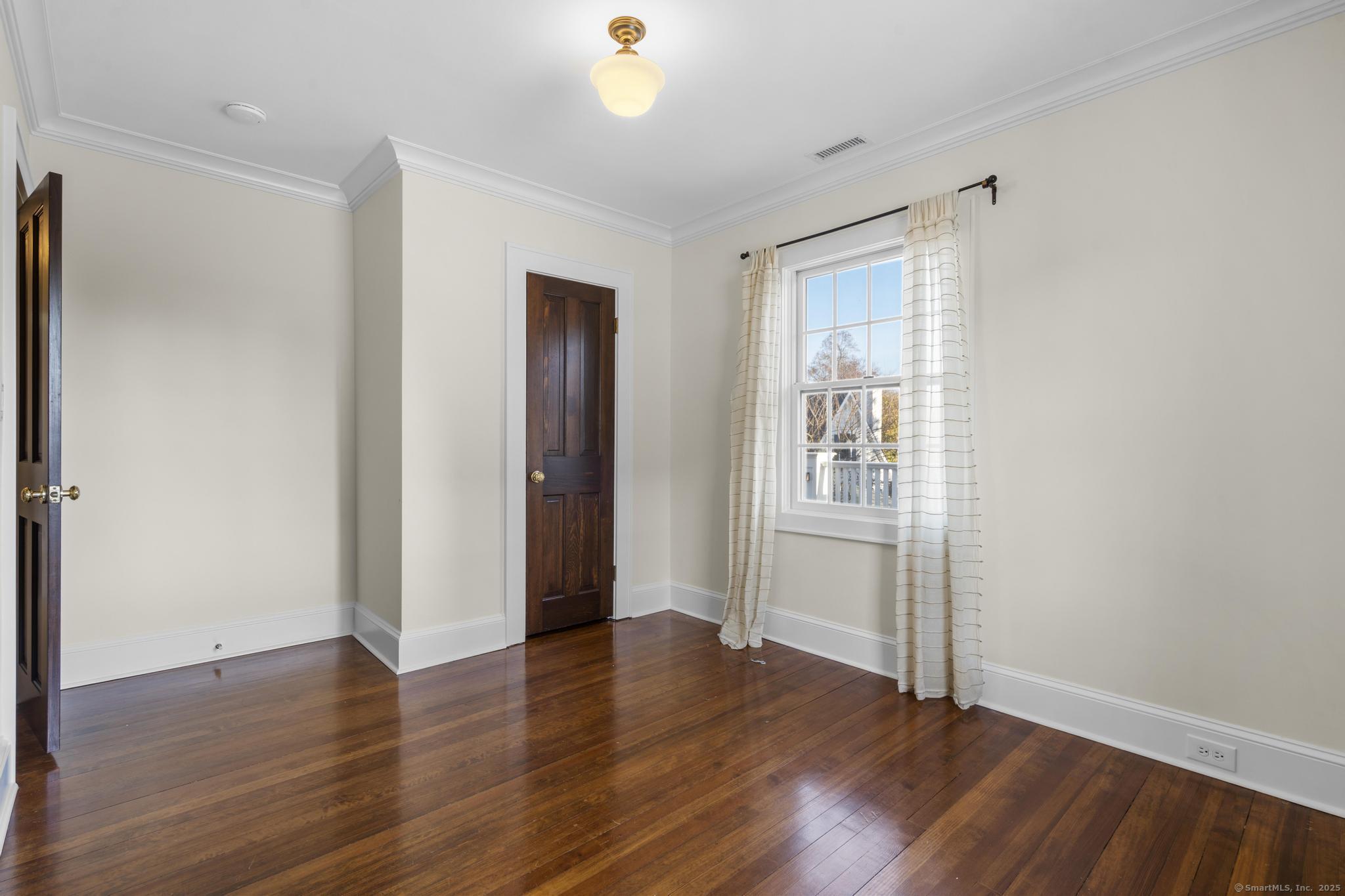 447 Reef Road Fairfield, CT 06824 - Photo 19 of 27 an empty room with wooden floor and windows