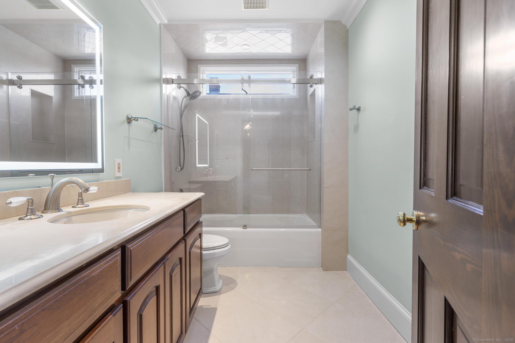 447 Reef Road Fairfield, CT 06824 - Photo 20 of 27 a bathroom with a granite countertop sink a toilet and shower