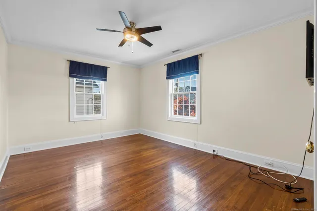 a view of a livingroom with a ceiling fan and wooden floor