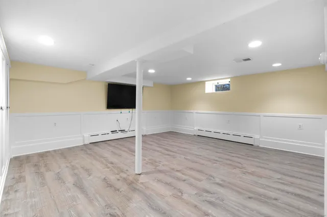 an empty room with wooden floor and mirror