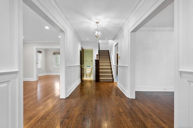 a view of a hallway with wooden floor and a kitchen