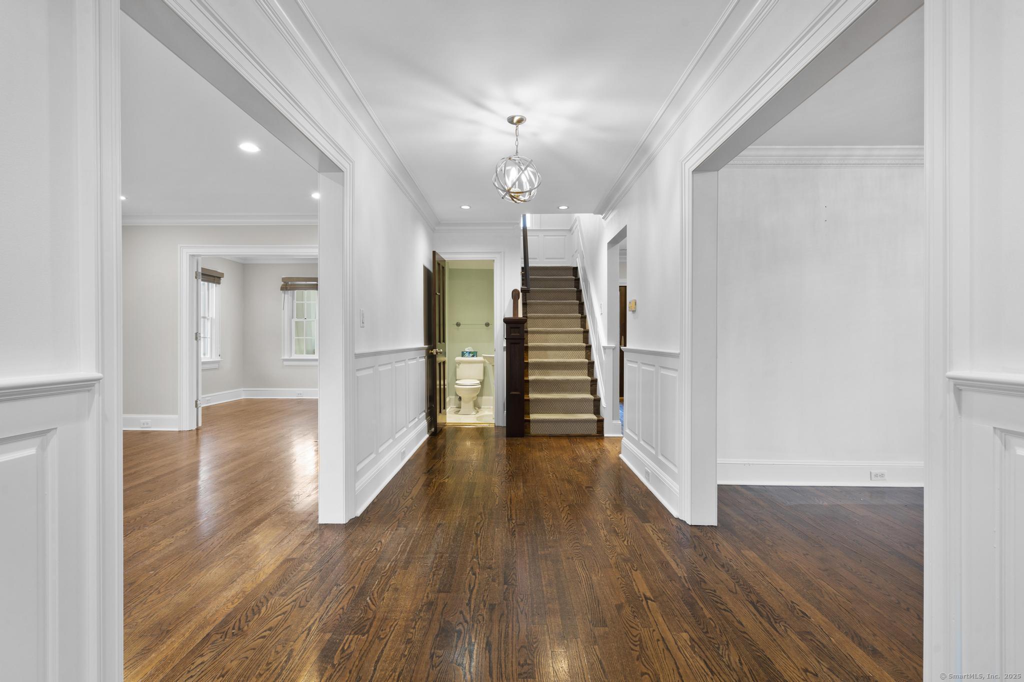 447 Reef Road Fairfield, CT 06824 - Photo 3 of 27 a view of a hallway with wooden floor and a kitchen