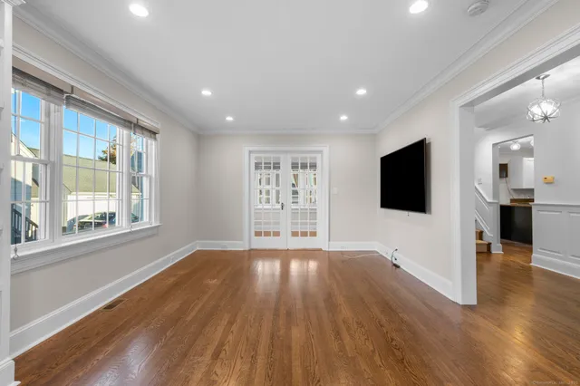a view of a big room with wooden floor and windows