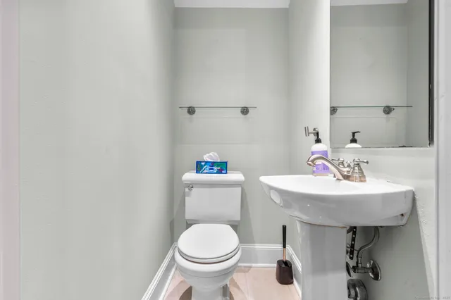 a bathroom with a sink toilet and a mirror