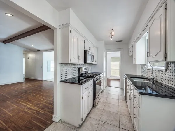 a kitchen with stainless steel appliances granite countertop a stove and a sink
