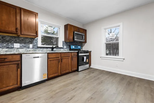 a kitchen with stainless steel appliances granite countertop a stove a sink and a microwave