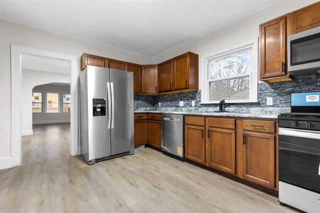 a kitchen with stainless steel appliances granite countertop a refrigerator sink and microwave