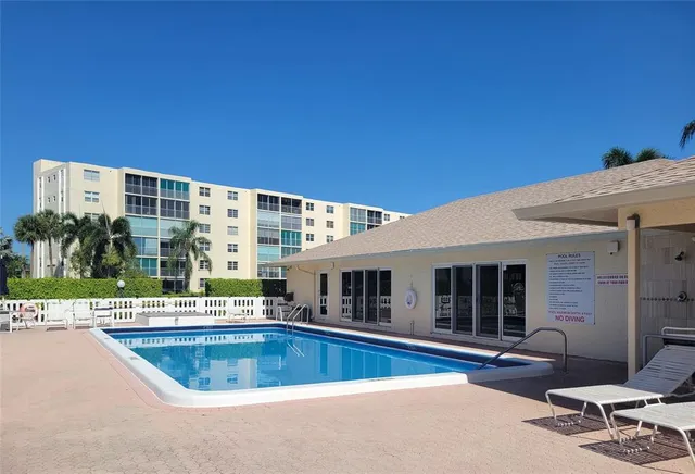 a view of a building with a swimming pool and sitting area