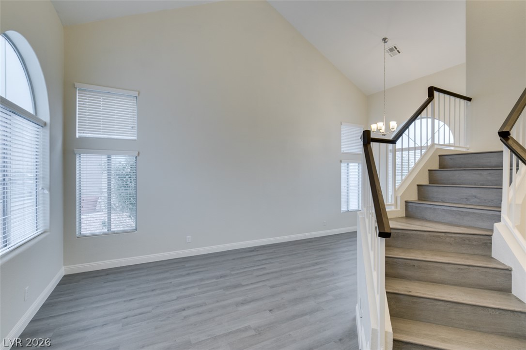 1738 Toltec Circle Henderson, NV 89014 - Photo 42 of 46 Bright, airy living space features soaring vaulted ceilings and elegant staircase with rich wood banister.