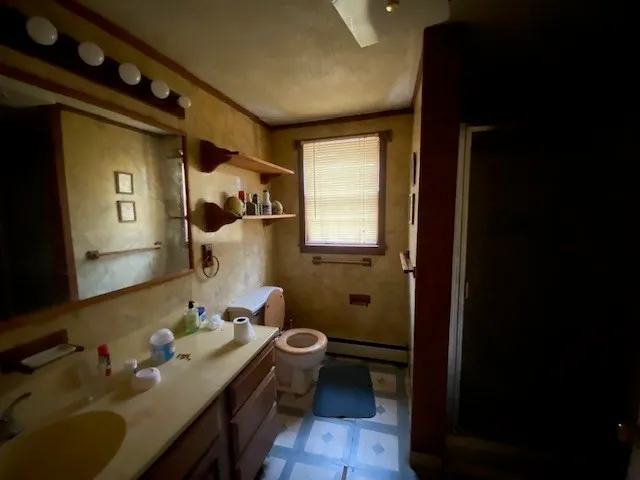 a bathroom with a sink vanity granite and toilet