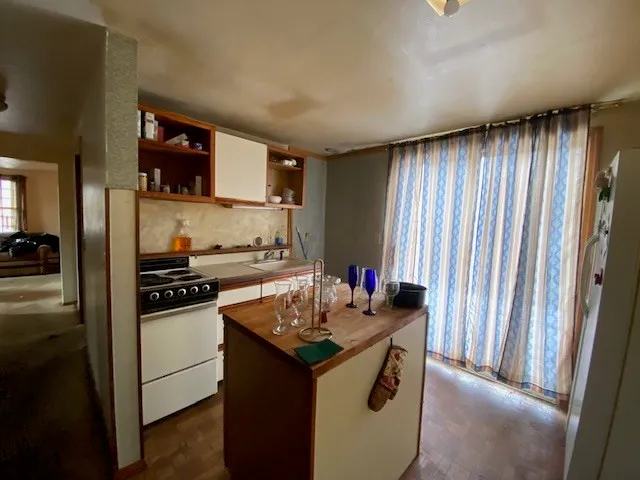 a kitchen with granite countertop a sink stove and cabinets