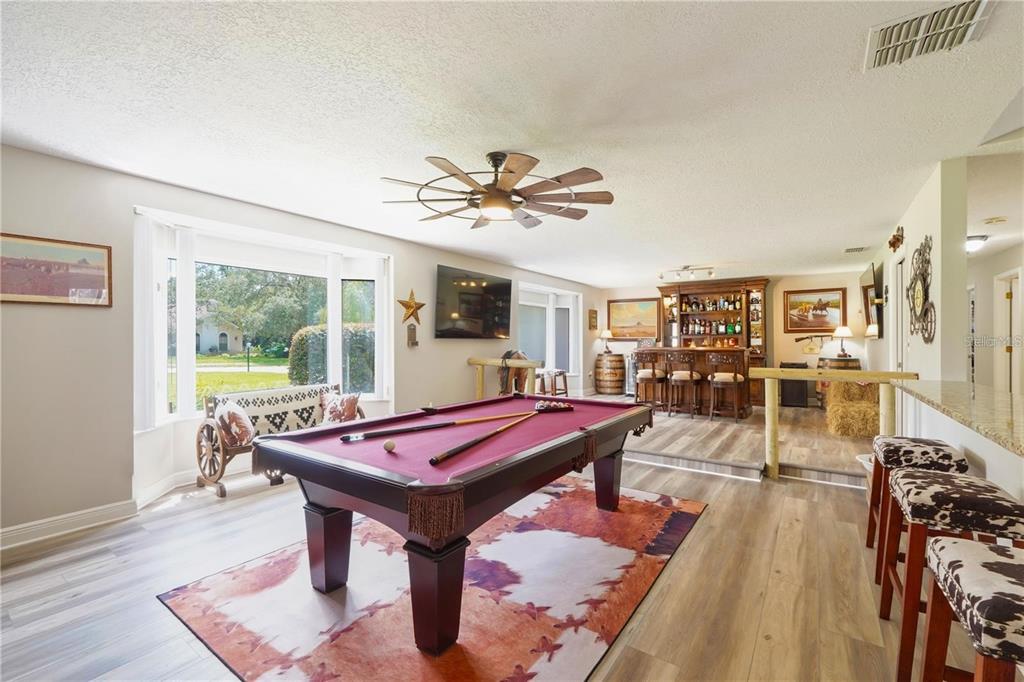 4603 Lake In The Woods Drive Spring Hill, FL 34607 - Photo 39 of 69 a living room with furniture pool table and a floor to ceiling window