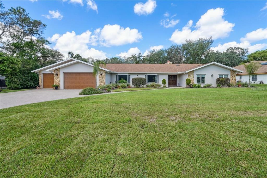 4603 Lake In The Woods Drive Spring Hill, FL 34607 - Photo 61 of 69 a view of a house with a big yard and potted plants