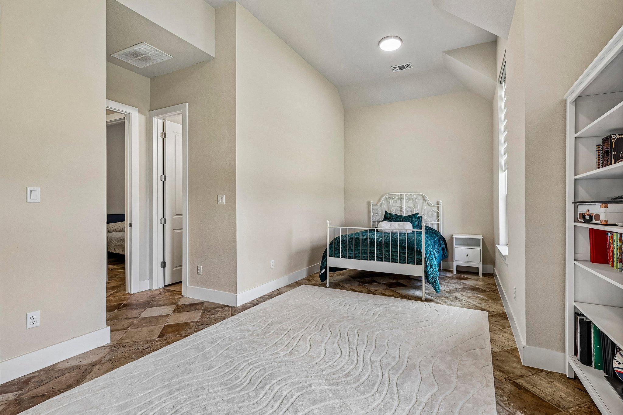 1705 Parten Rnch Parkway Austin, TX 78737 - Photo 14 of 39 A quiet bedroom featuring vaulted ceilings, recessed lighting, and durable tile flooring.