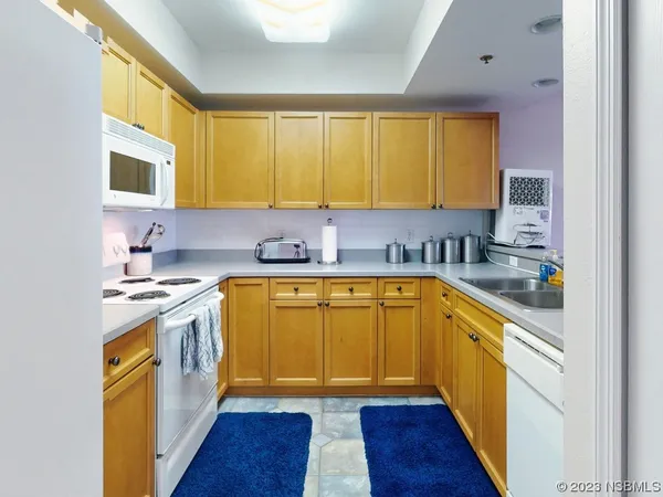 a kitchen with a sink a stove cabinets and wooden floor