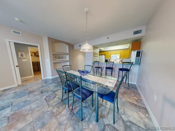 a dining room with furniture a chandelier and wooden floor