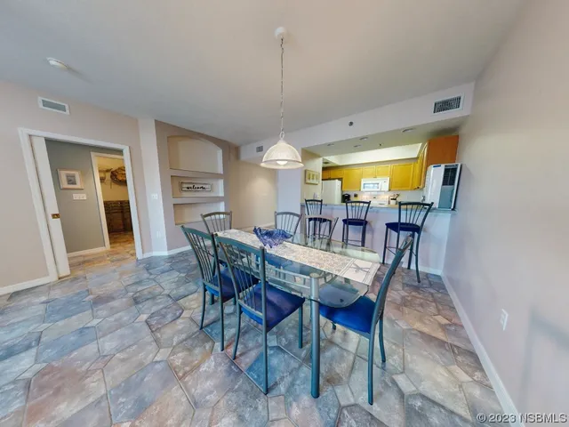 a dining room with furniture a chandelier and wooden floor
