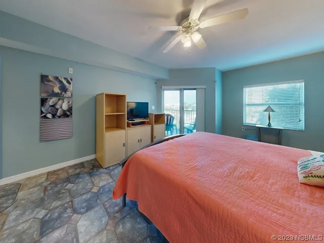 a bedroom with a large bed a chandelier and dresser
