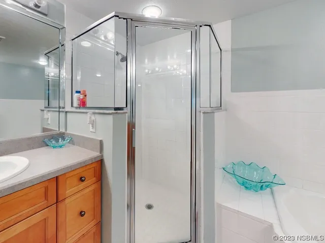 a bathroom with a granite countertop shower a sink and a mirror