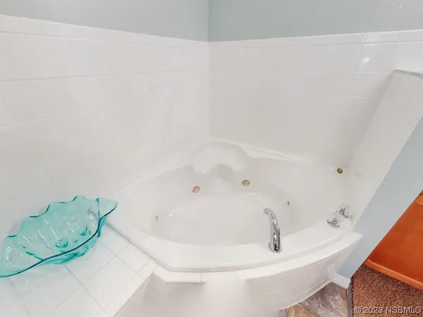 a bath tub sitting next to a white sink and vanity
