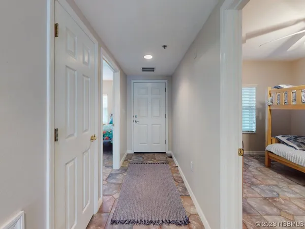 a view of a hallway with wooden floor and a living room