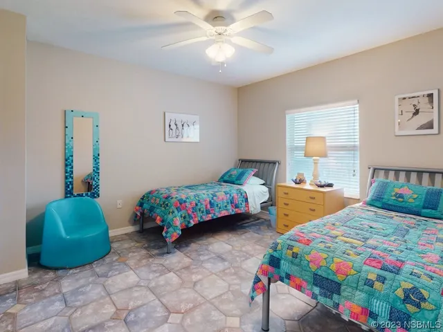 a bedroom that has two beds and a chair in it