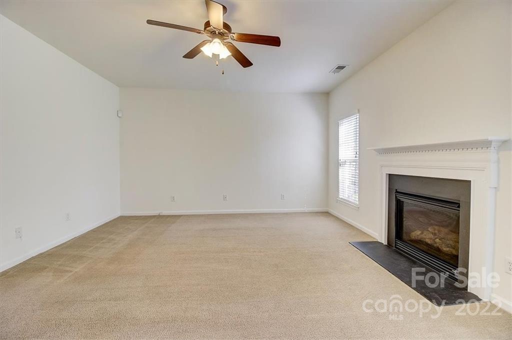 11223 Winget Pond Road Charlotte, NC 28278 - Photo 12 of 43 an empty room with fireplace and fan