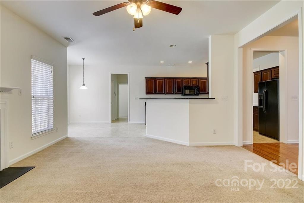 11223 Winget Pond Road Charlotte, NC 28278 - Photo 13 of 43 an empty room with a kitchen and a chandelier fan