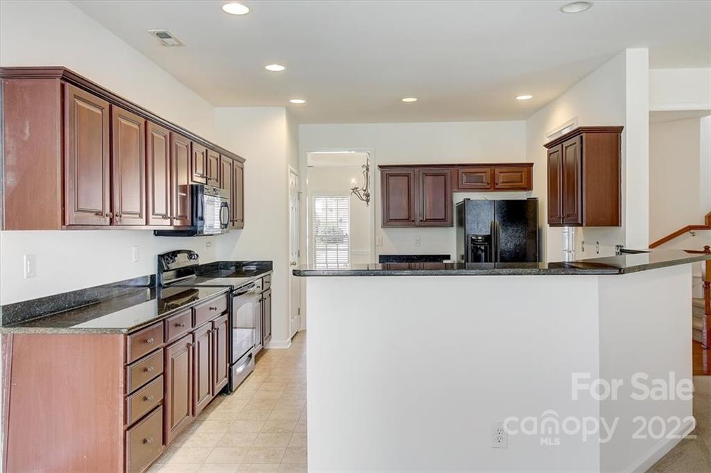 11223 Winget Pond Road Charlotte, NC 28278 - Photo 16 of 43 a kitchen with stainless steel appliances granite countertop a stove top oven a sink a refrigerator and a granite counter tops