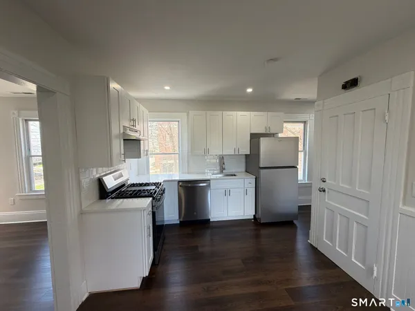 a kitchen with a sink wooden floor and stainless steel appliances